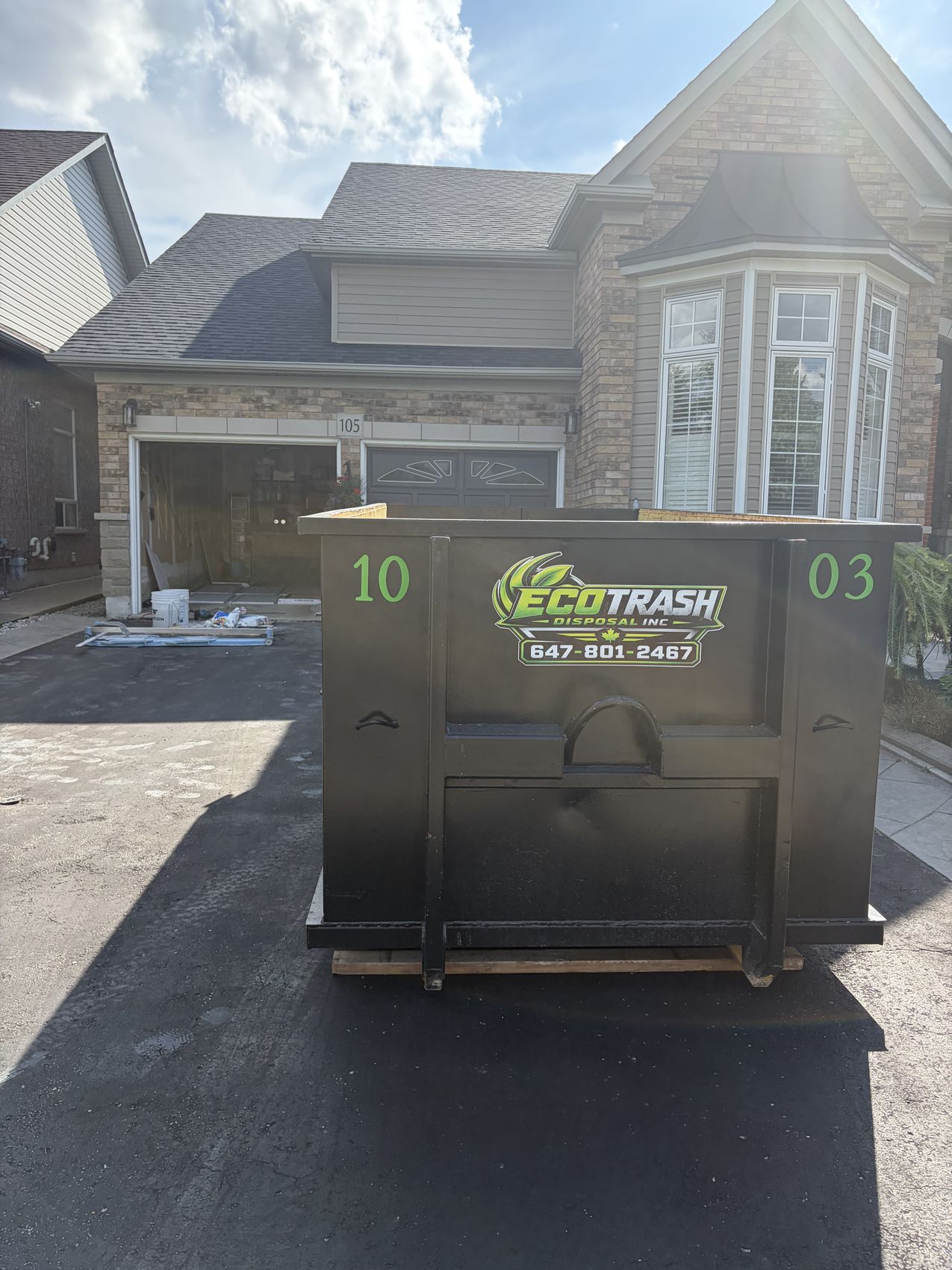 Clean black Eco Trash 10 yard bin on a driveway